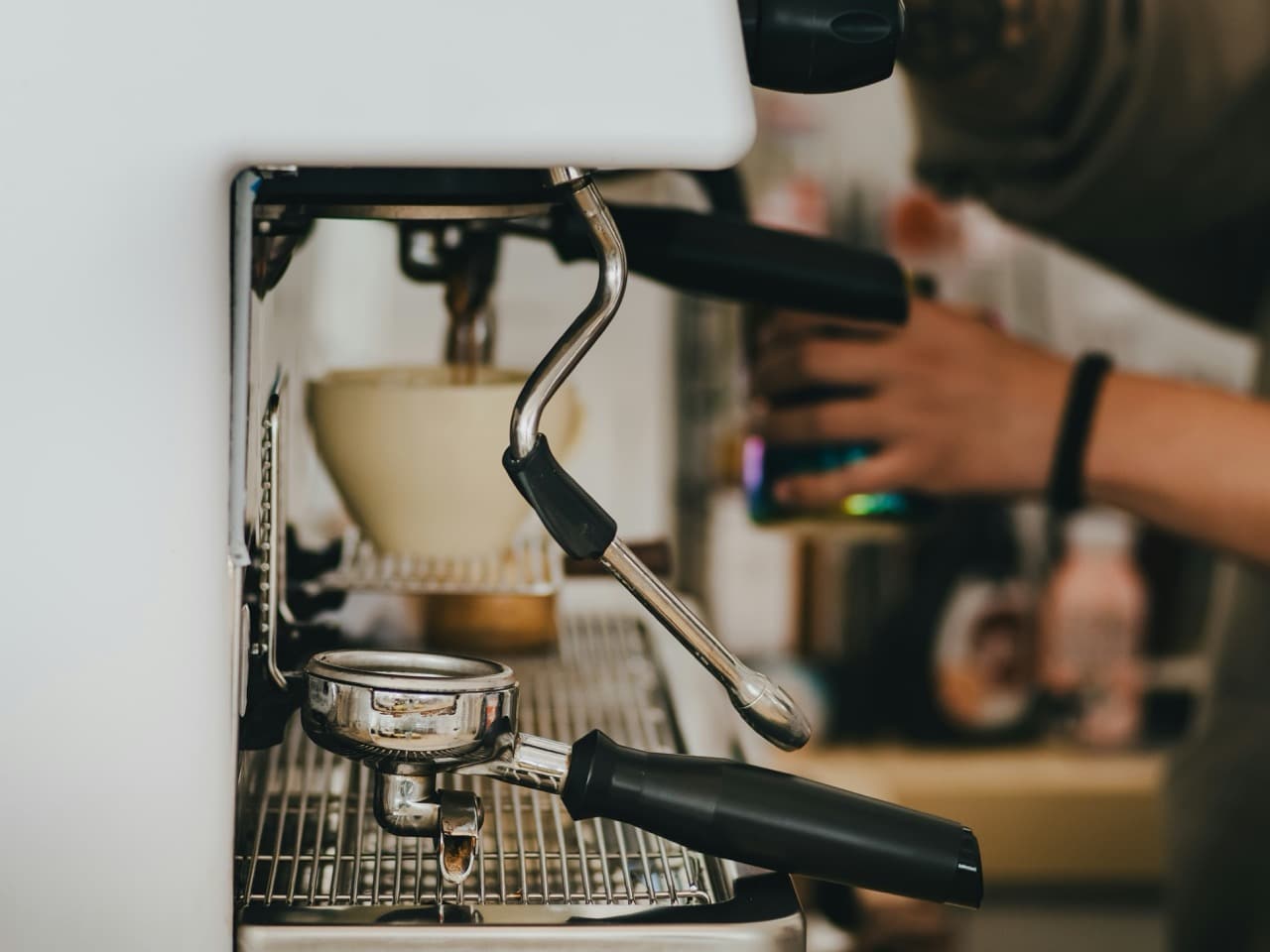 barista making milk on espresso machine. a well running espresso machine that is maintained regularly doesn't need coffee machine repair